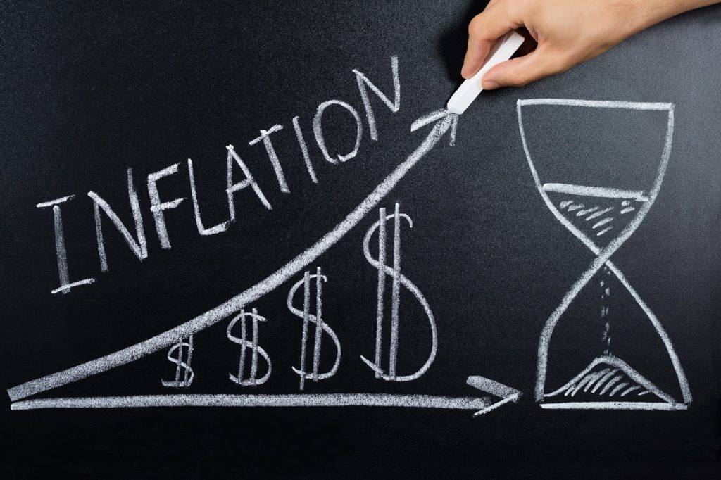 Main dessinant la courbe de l'inflation avec un sablier